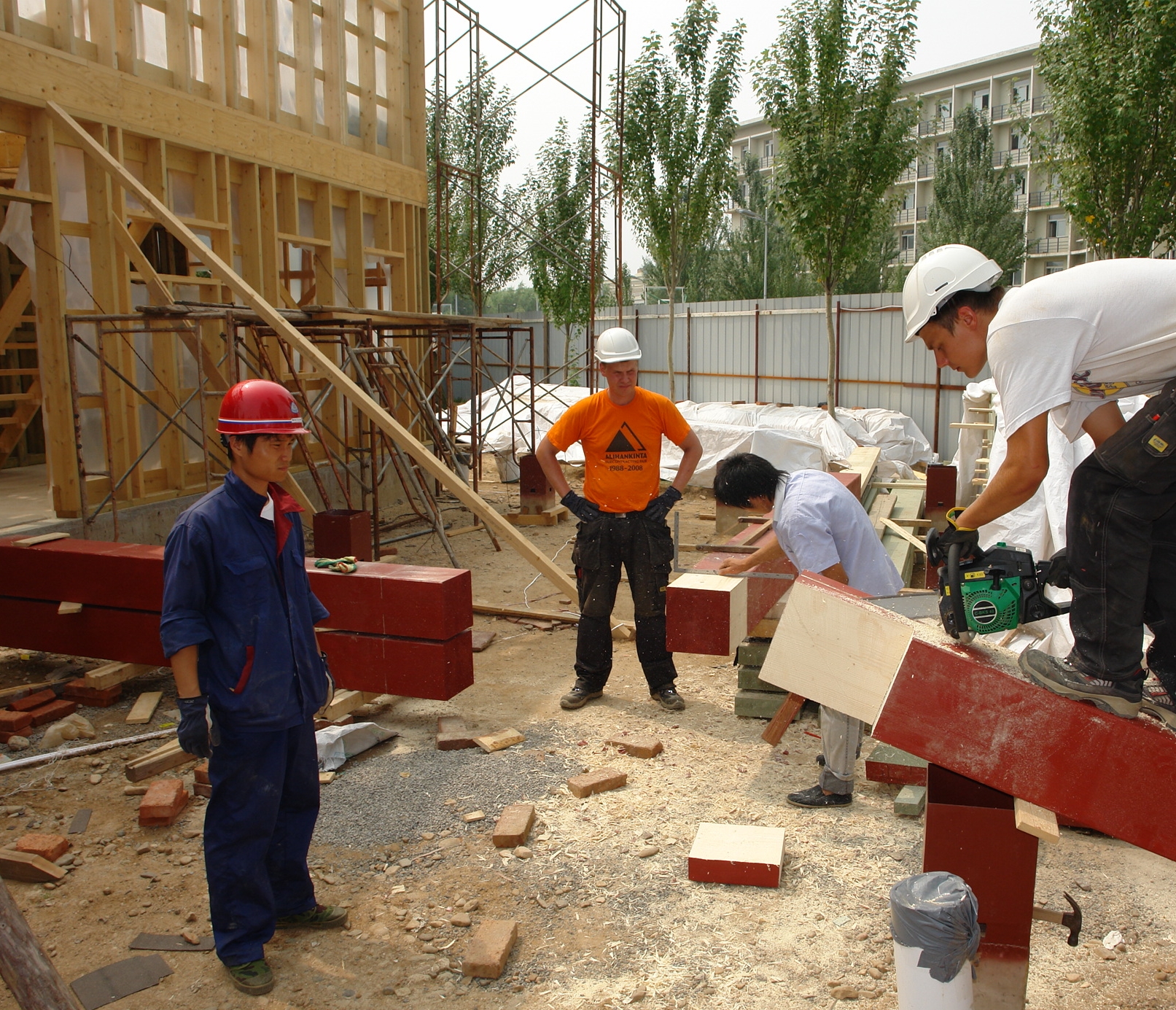 Xia Huanhuan (vas.), Miikka Huhtamäki, Shefu Wang ja Ville Lehtineva rakentavat taloa.