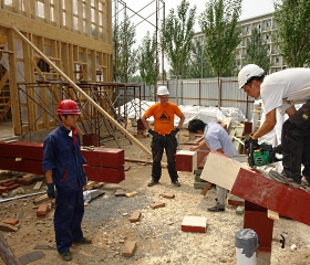 Xia Huanhuan, Miikka Huhtamäki, Shefu Wang ja Ville Lehtinen rakentavat taloa.